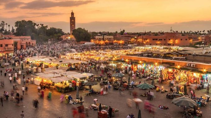 Place Jemaa el-Fna – Marrakechjama-el-fnaa Chaque ville a son agora, le lieu où bat le cœur de sa population. Pour les Marrakchis, pour les Marocains et pour le monde entier, Jemaa El Fna incarne l’identité de Marrakech. La place Jemaa El Fna est sans aucun doute le symbole international de Marrakech et plus largement, du Maroc. Mais derrière cette figure de carte postale où se croisent des millions de touristes chaque année, où bruisse de jour comme de nuit une foule bigarrée, il y a cette magie propre à Marrakech, ce carrefour où se rencontre le monde, cet endroit où l’humanité nomade prend le temps de stopper sa course effrénée pour partager un moment, pour remplir sa besace ou en vendre le contenu…  Le musée vivant du patrimoine oral du Maroc C’est carrefour, un lieu de brassage, un espace où les ethnies, les classes sociales et les générations se côtoient et échangent. Depuis les conteurs jusqu’aux musiciens et les danseurs en transe, en passant par les charmeurs de serpents, les dresseurs de singes, les herboristes, les prêcheurs, les voyants, les acrobates, les prestidigitateurs, les guérisseurs, la place est la fontaine perpétuelle des arts du langage à tel point qu’en 2001, l’UNESCO décidait d’inscrire Jemaa El Fna au patrimoine culturel immatériel de l’humanité.  serpent-jamaa-el-fnaa-marrakech Le plus ancien témoignage la concernant date de 1573. Nous le devons à Luis del Mármol Carvajal un explorateur espagnol qui décrit une ruche bourdonnante de vie : “une grande place, au milieu de laquelle il y a une butte de terre plus haute que les boutiques et les maisons d’alentour, où l’on exécute les malfaiteurs”. La place des trépassés, telle est la traduction littérale de la place Jemaa El Fna, même si d’autres hypothèses de traduction viennent rajouter au mystère du lieu.  L’aventurier poursuit son récit : “il y a plusieurs boutiques en cette place, des serruriers, des cordonniers, des charpentiers et toutes sortes de gens qui vendent des choses bonnes à manger. L’un des côtés est le lieu où l’on vend de la soie et des étoffes de lin, de coton et de laine fine. C’est le lieu de la douane où se tiennent les marchands chrétiens d’Europe avec leurs marchandises et où se fait le plus grand trafic de la ville”.  jama-el-fnaa-ancien Un demi-siècle plus tard, un autre espagnol de passage décrira la place comme un « maremagnum d’odeurs, de sensations, d’images, d’infinies vibrations, une cour splendide au royaume des charlatans et des fous ».  Un voyageur français en fera ainsi le portrait : « la place de l’imprévisible, de l’éphémère, du délire collectif et de la création spontanée ».  Parce qu’elle est incontournable dans le parcours touristique marocain, il fait peu de doute que vous partirez vous aussi, à votre tour, à la découverte de ce lieu mythique. Vous la décrirez alors avec vos propres mots, selon votre propre ressenti. Mais une chose est sûre, on n’oublie jamais son passage en ce lieu à nul autre pareil…